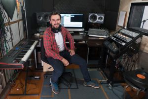 Happy music producer working at a recording studio - arts and entertainment concepts